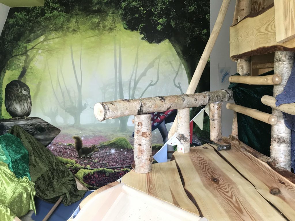 Kinderzimmer mit Wald-Tapete und Holz-Hochbett
