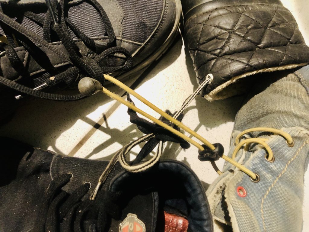 4 an den Schnürsenkeln zusammengebundene Schuhe