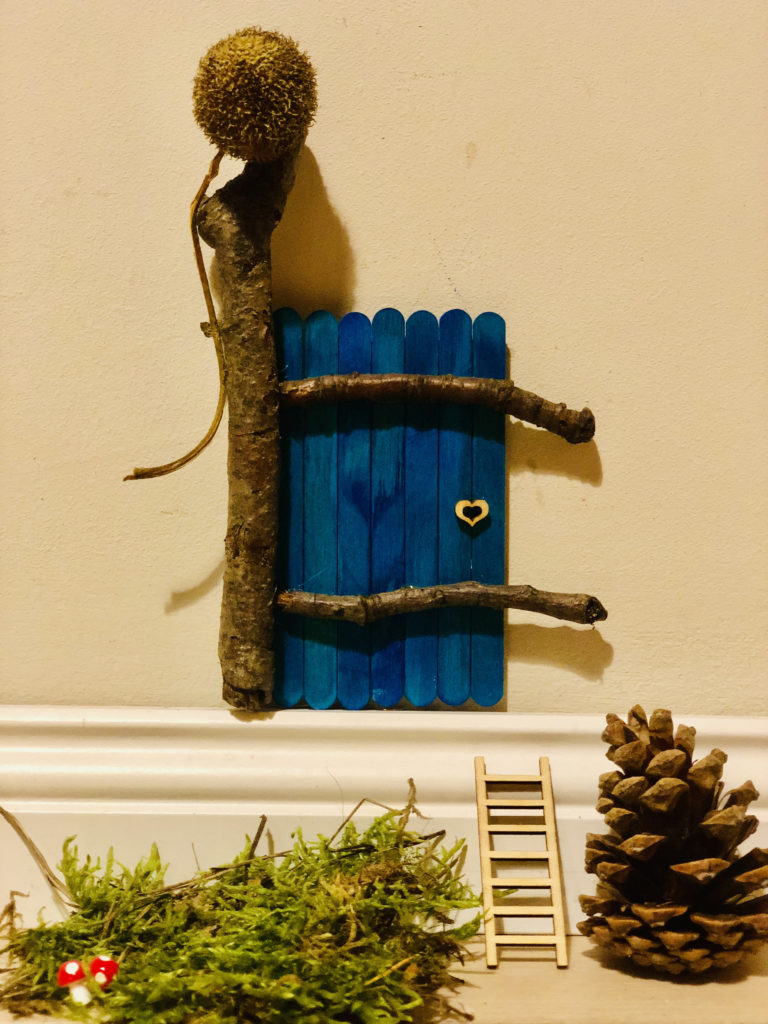 blaue Wichteltür mit Holz